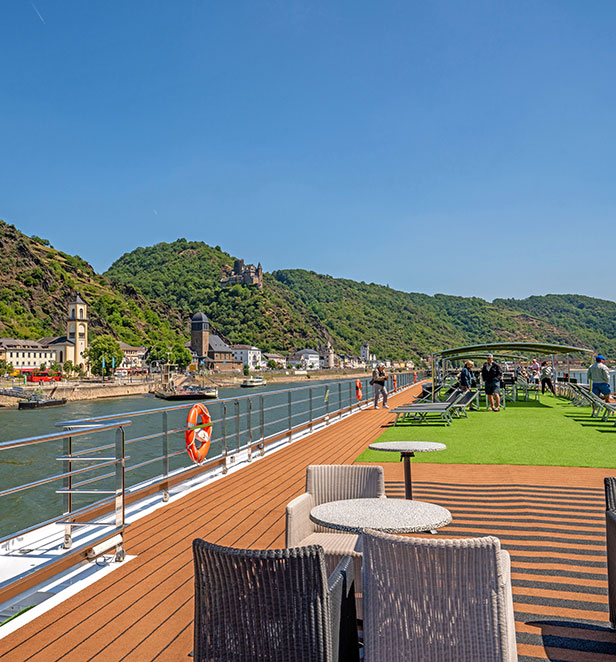 The panoramic Sun Deck on a Scenic cruise ship, with a walking track and views of the river and passing landscapes.