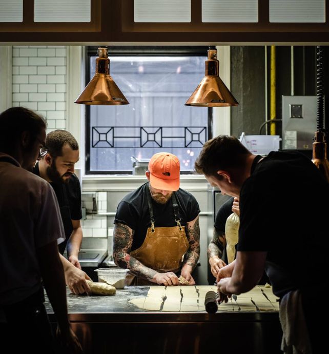 Chef Dale MacKay making Perogy's in a kitchen with staff